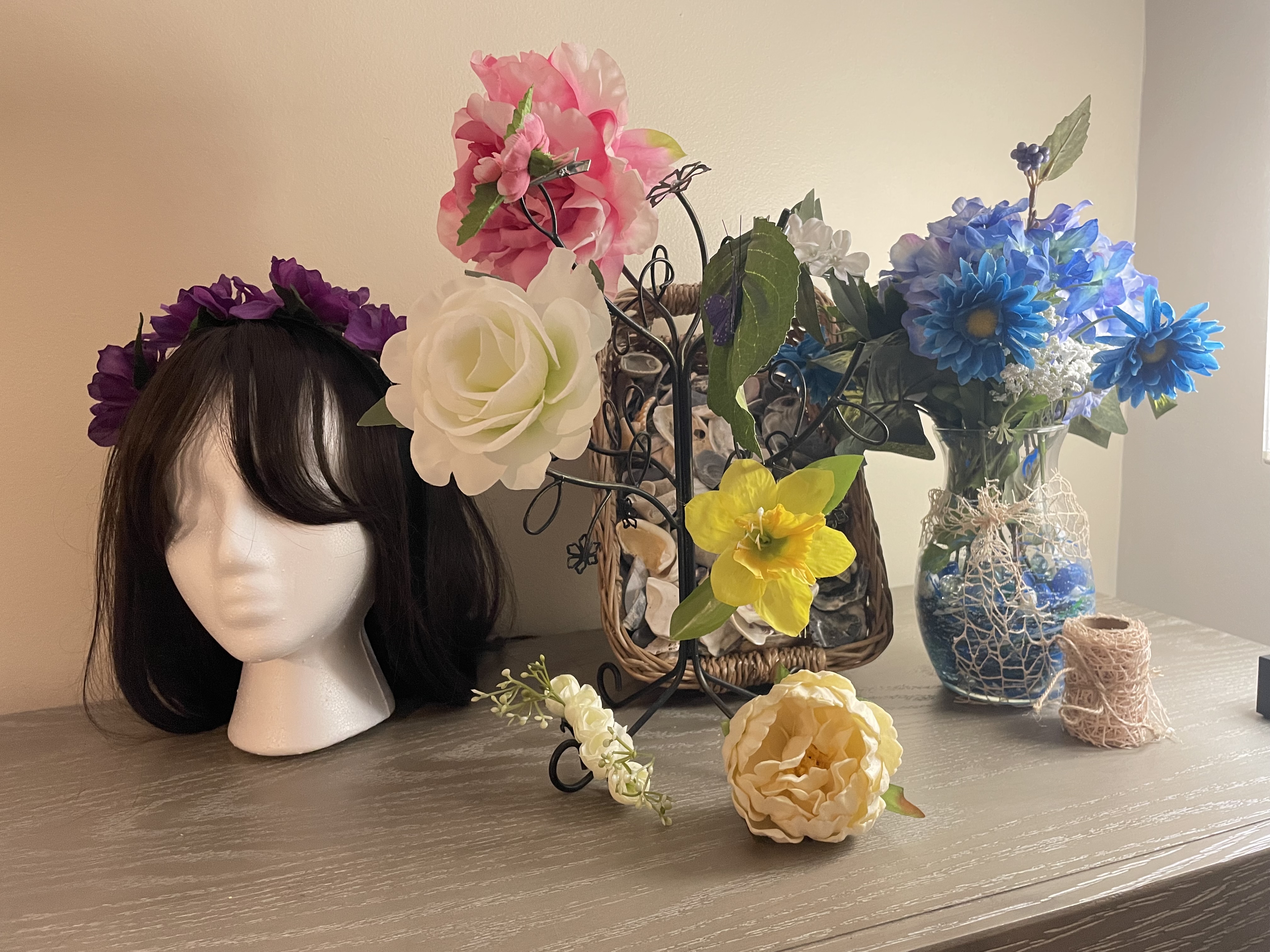 Sample products including hair clips, painted vase, and floral headband.  Staged in front of natural seashell filler