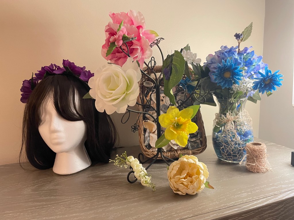 Sample products including hair clips, painted vase, and floral headband. Staged in front of natural seashell filler